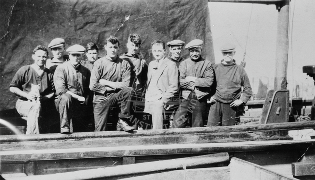 Group of men on board boat with cat