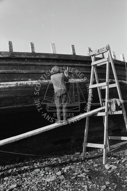 Boat undergoing maintenance in harbour, 1978