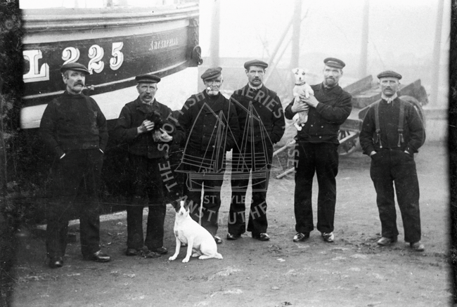 Group of men and three dogs beside 'Enterprise