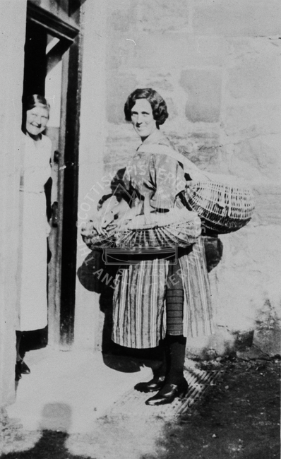 Portrait of a fishwife carrying baskets.