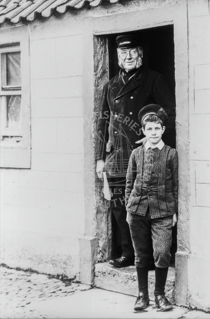 Fisherman and boy standing in doorway of a house