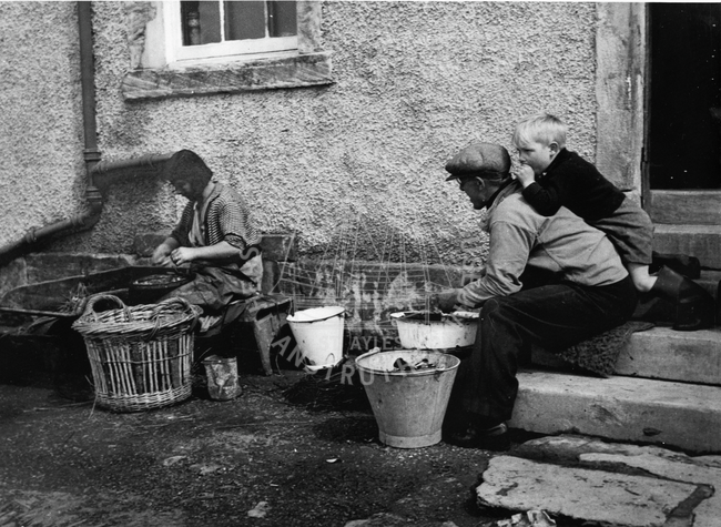Man shelling bait and woman baiting lines