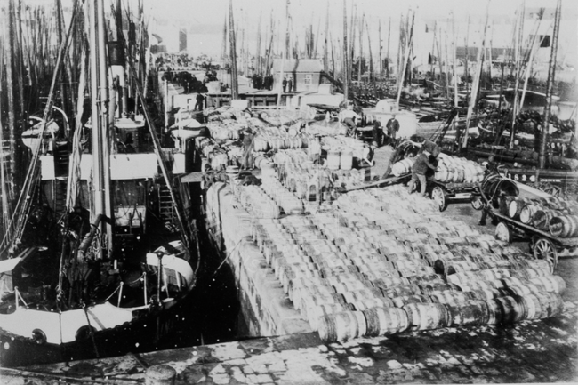 Barrels of herring being load aboard foreign