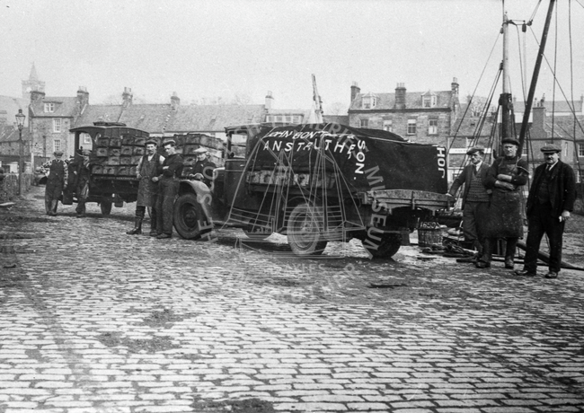 Group of men and two fish vans.