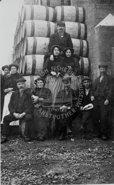 Herring gutters posed in front of barrels with