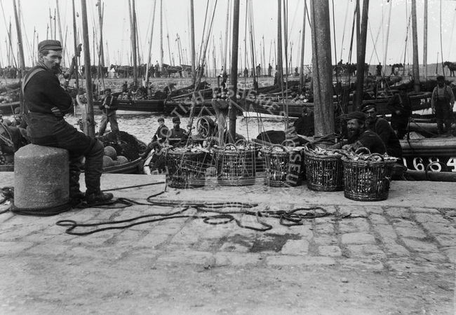 Fisherman seated posed beside quarter cran