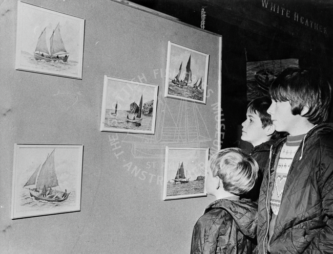 Children looking at illustrations of sail boats