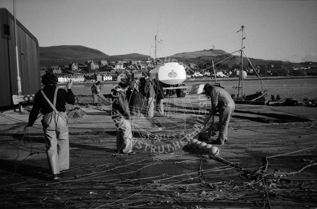 Crew of 'Aquila' OB99 mending nets on newly