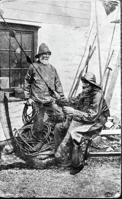 Fishermen in oilskins mending nets, 1907