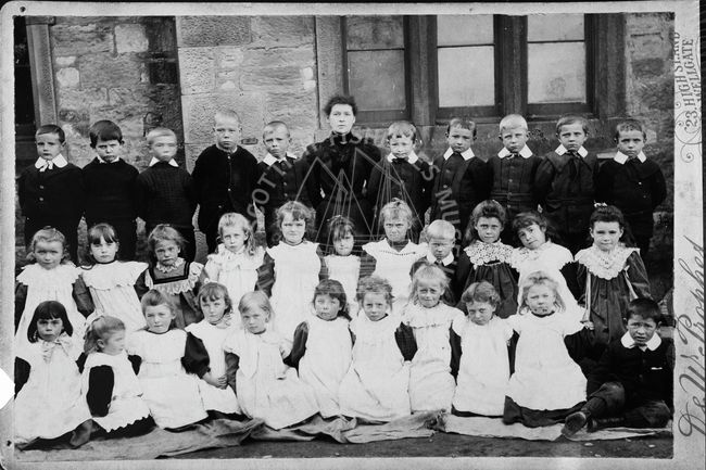 Group of children with one woman, 1894 onwards.